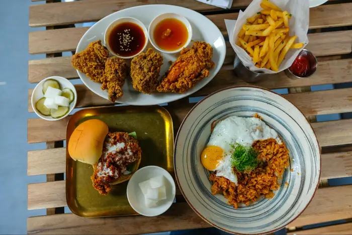 plates of fried chicken, fries, pickles on table